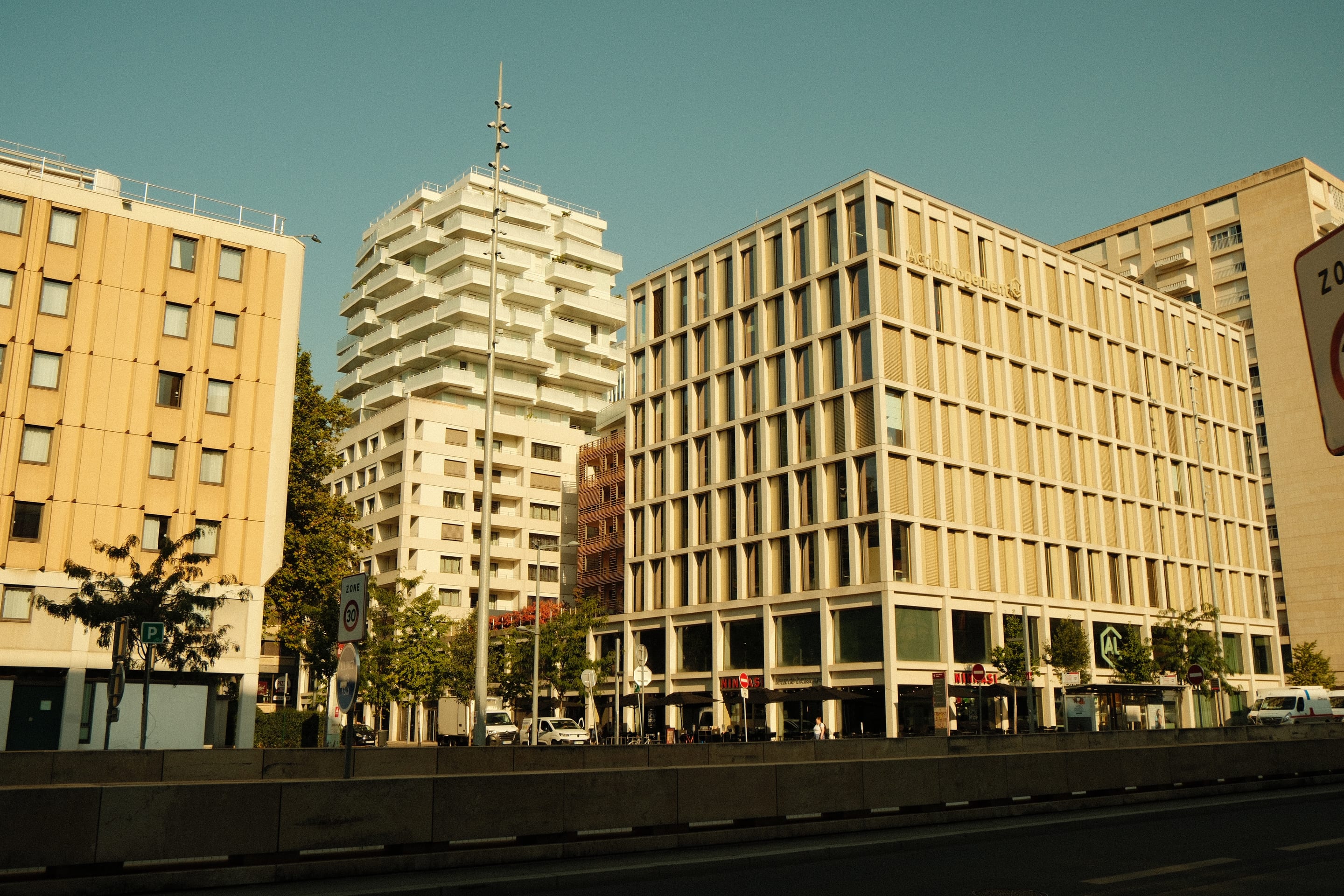 The façades across the road, three decades of them in one frame.